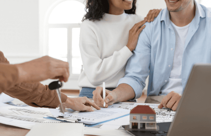smiley-couple-signing-contract-new-house