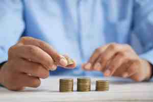 Person stacking coins representing financial growth and wealth management.